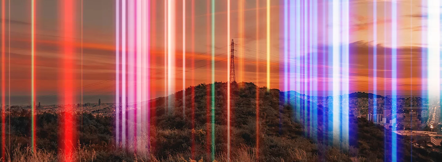 A large hill with an electrical tower stands against an orange and pink sunset sky. Multiple vertical streaks of vibrant colors, including red, blue, and purple, cascade down the image, creating an effect of light beams passing through the scene. A cityscape is visible in the background.